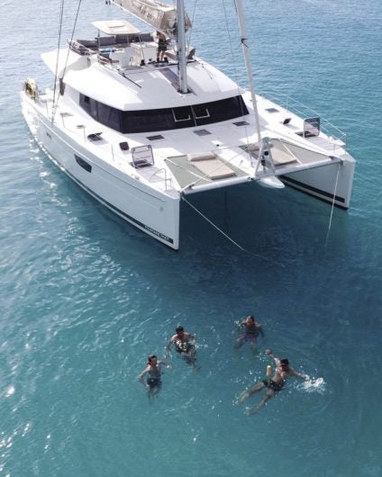 People swimming near catamaran