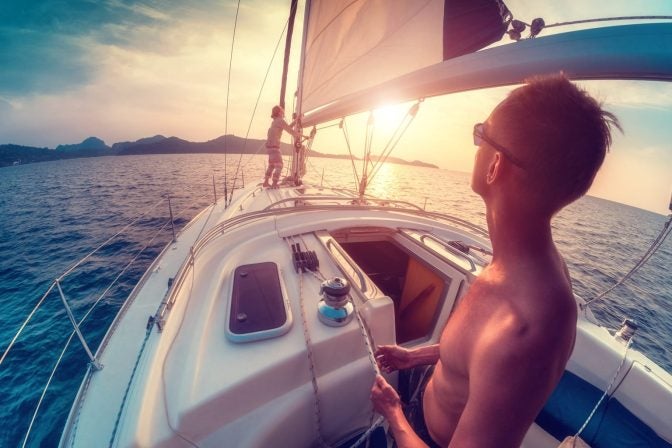 adjusting sails at sunset